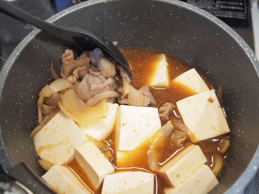 豆腐とねぎを加えて煮込む