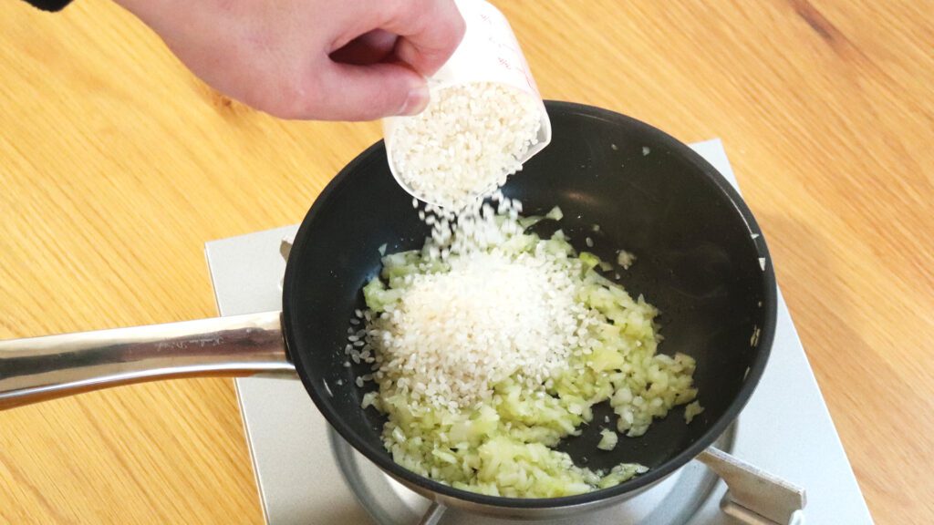 玉ねぎがしんなりしたら、生米を炒めよう