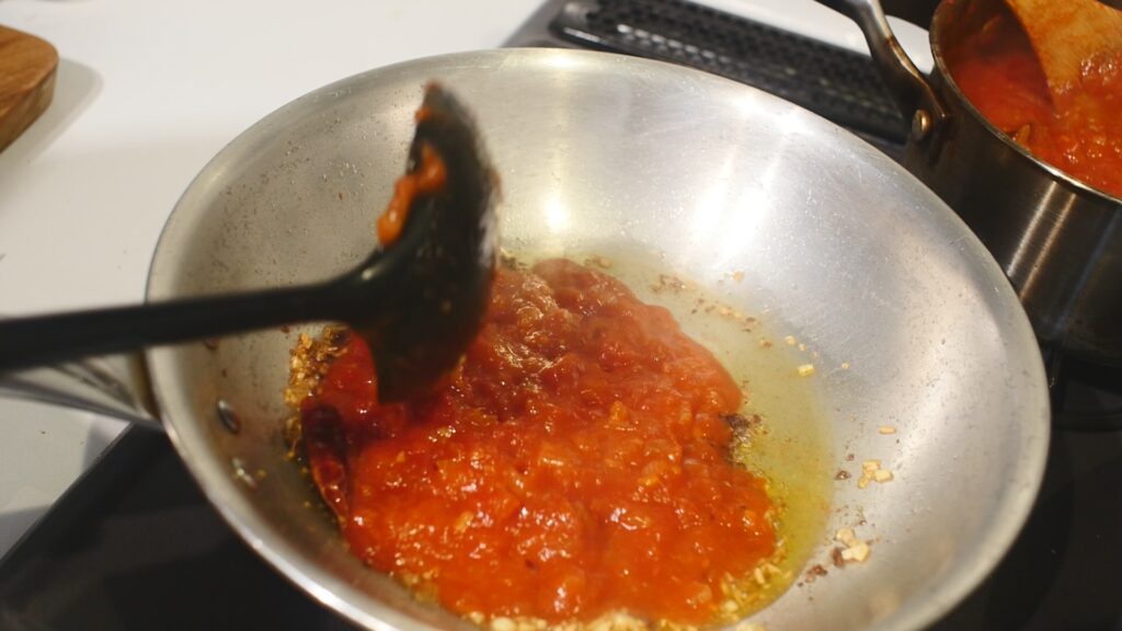 じっくり炒めたら、トマトソースとパスタのゆで汁を入れる