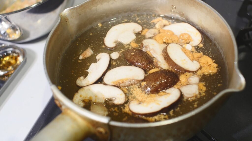 鍋に水、椎茸、顆粒鶏がらスープを入れ火にかけ、鶏団子を入れる