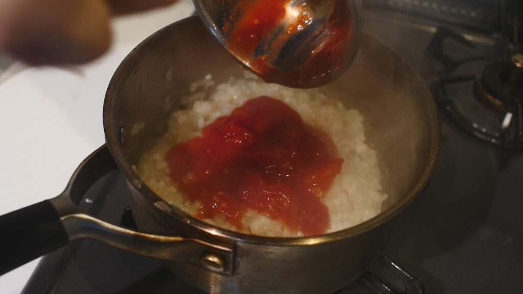 トマト缶を入れ、煮詰めていく