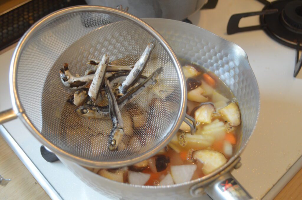 炒めた野菜に煮干し出汁を入れ煮立たせる