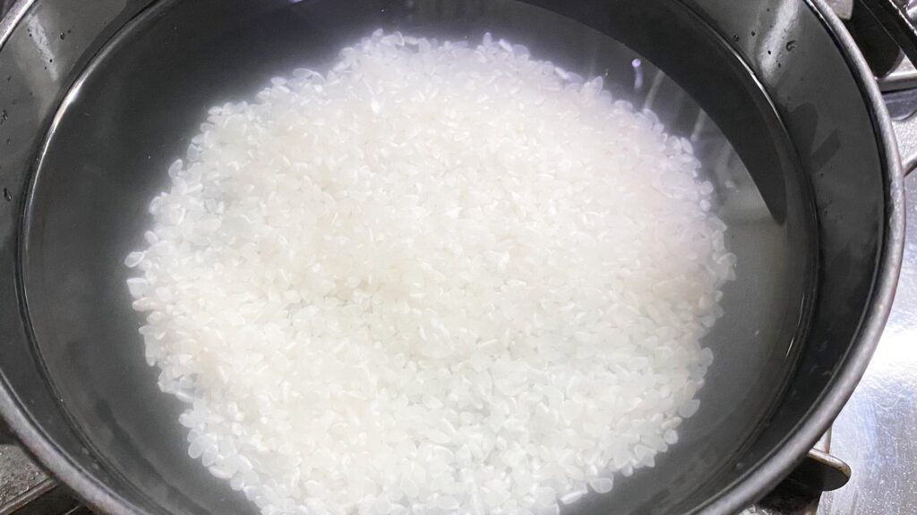 研いだ生米と水を鍋に入れる