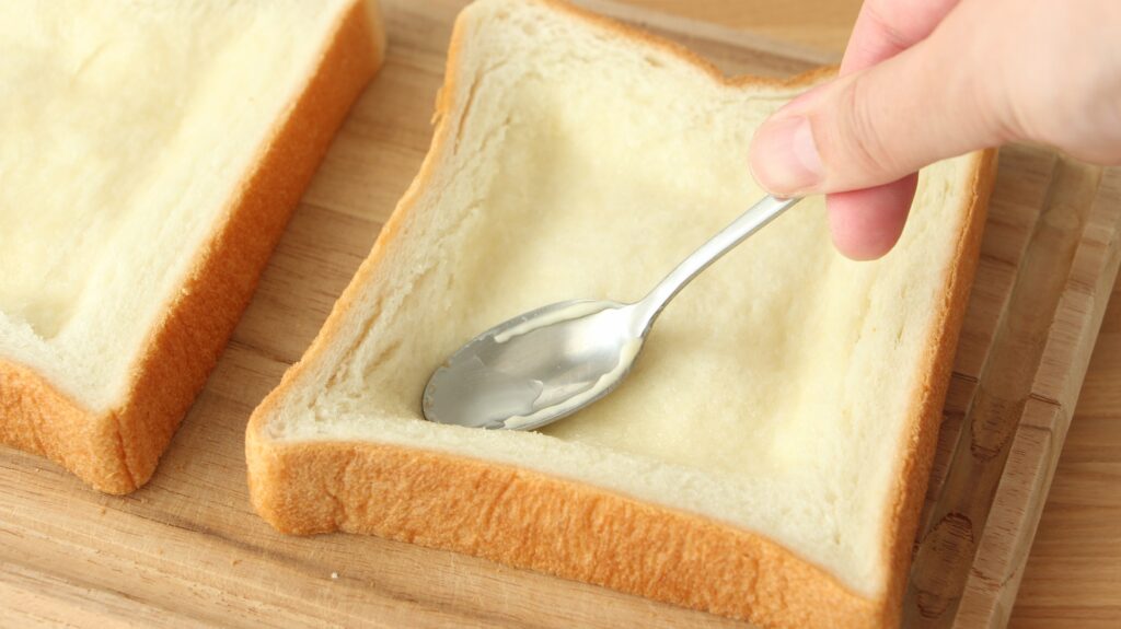 食パンの内側にくぼみを作ってツナを広げる